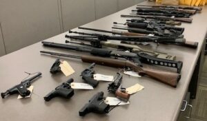 Photo of 20 firearms seized during a search warrant.