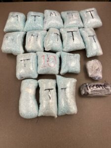 Evidence photo of approximately 160,000 Fentanyl pills in various plastic wrapping.