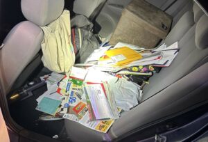 Loose mail on the back seat of a car.